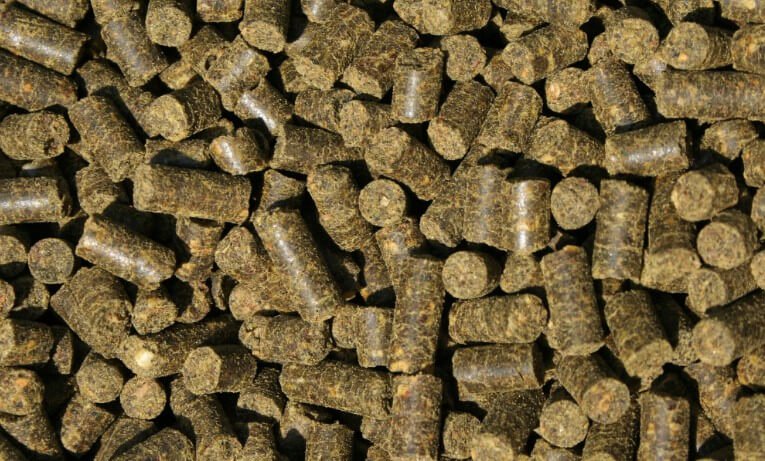Ein Haufen grüner Pellets mit braunen und schwarzen Farbtönen