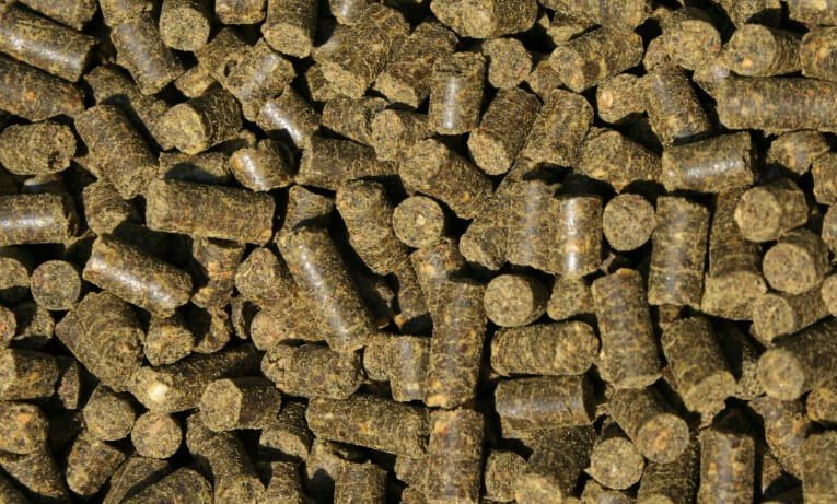 Ein Haufen grüner Pellets mit braunen und schwarzen Farbtönen